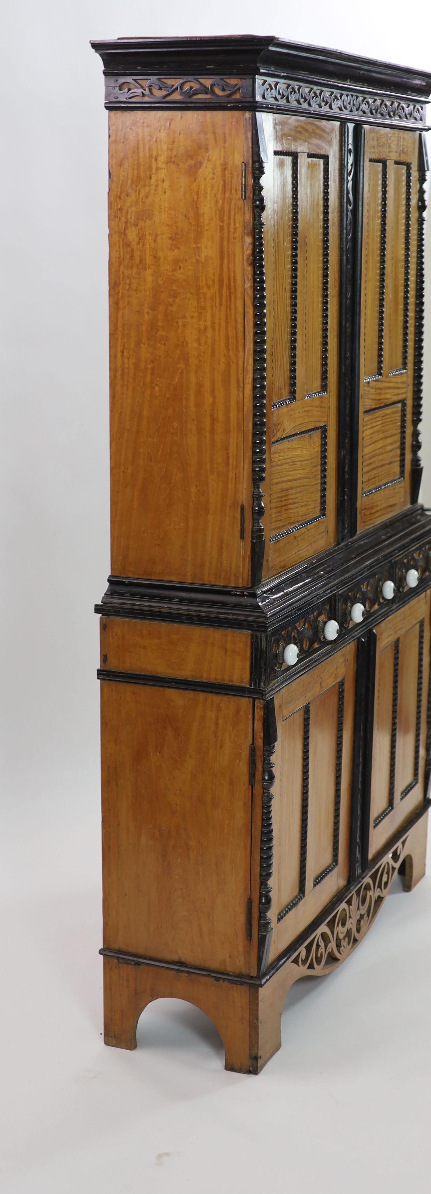 A mid 19th century Ceylonese satinwood and ebony side cabinet, H 194cm. W 120cm. D 37cm.
